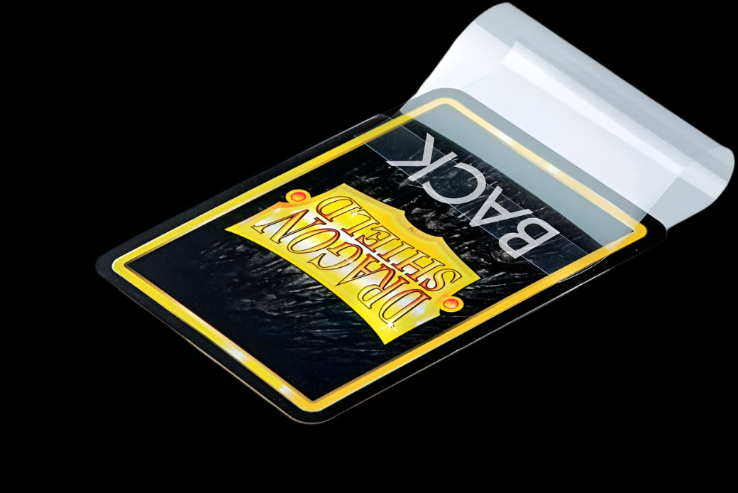 A trading card partially inserted into a clear Dragon Shield perfect fit sleeve with the resealable flap open.